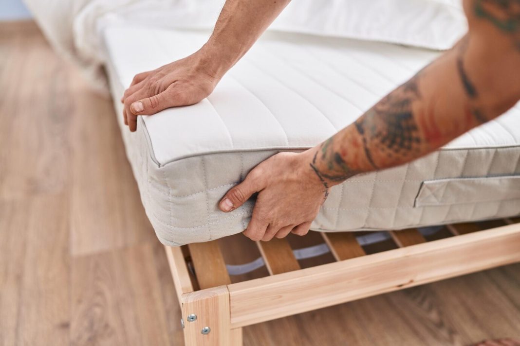 young-man-holding-mattress-bedroom_839833-2670